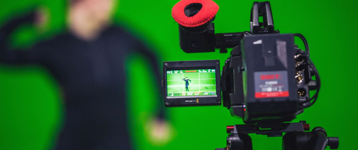 Persoon achter camera voor een green screen