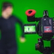 Persoon achter camera voor een green screen