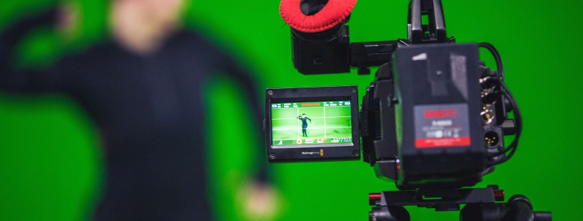 Persoon achter camera voor een green screen